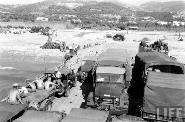 USMC M38A1 Jeeps and M35 cargo trucks reembarking. Note the Confederate flag on the cargo truck.